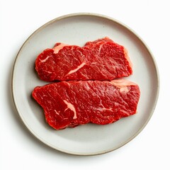 Plate of raw beef steaks isolated on white background, top view.