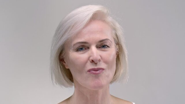 Old woman takes a yellow capsule with fish oil with hand. Senior female eats a pain pill or dietary supplement, taking medicine. Analyzing, Industry Medication. Elderly lady puts the drags in mouth