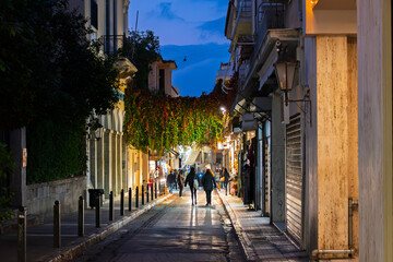 Fototapeta premium Late night in the historic and touristic Plaka district with illuminated shops and cafes, in Athens, Greece.