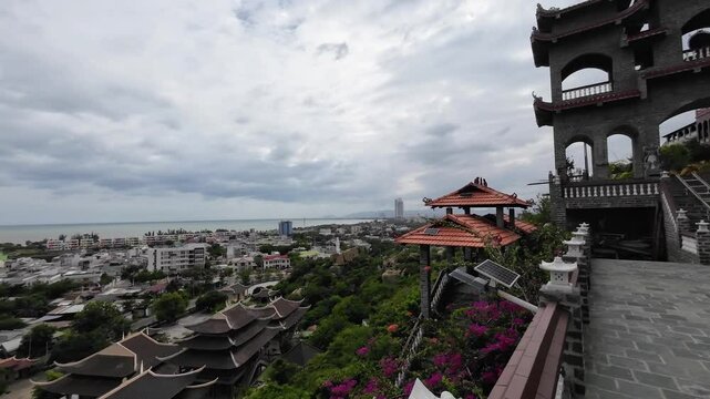 Temple perched on a hill in Vietnam, offering breathtaking views of the coastal town's cityscape in Phan Rang.
Panoramic view from Mountain over shimmering ocean and vibrant city with Rice Fields.