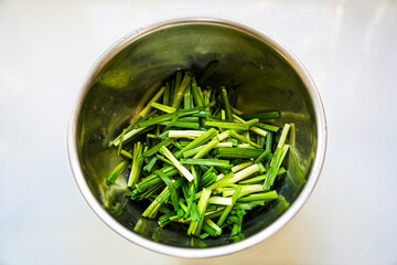 Photo of chives on a food bowl which is a condiment for preparing Pad Thai in the kitchen.