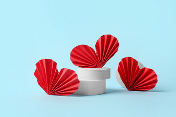 Decorative podiums with red paper hearts on blue background. Valentine's Day celebration