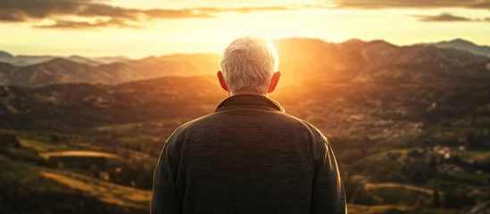 Fototapete Rund Elderly man enjoying a breathtaking sunrise in mountainous landscape with space for personalized text or messaging © The 2R Artificiality