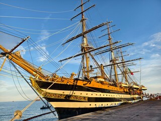 A large old ship at pier under a beautiful blue sky