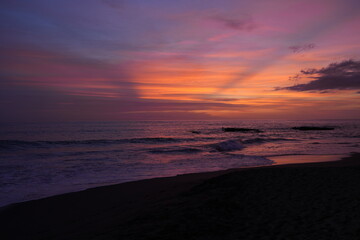 Obraz premium The ocean coast with a beautiful purple sunset. Waves in the sea. Wonderful mesmerizing landscape