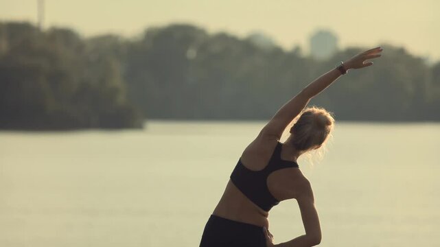 Woman is doing warm-up and stretching exercises before fitness