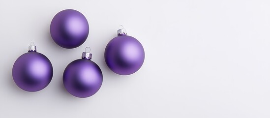 Fototapeta premium Elegant arrangement of purple Christmas ornaments on a clean white background emphasizing festive holiday spirit and decoration themes