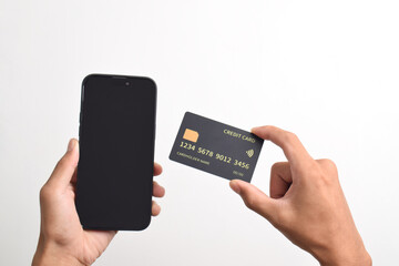 Male hands holding mobile phone and black credit card isolated on white background. Mobile payment ,Online shopping concept