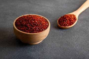 Red pepper flakes.Red chili peppers in wooden bowl on gray background.Dried chili peppers
