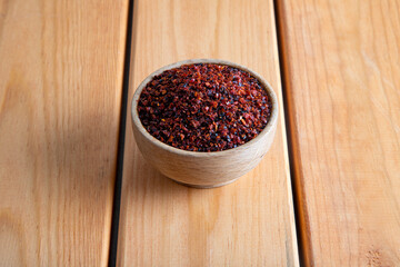 Red pepper flakes.Red chili peppers in wooden bowl on wooden table.Dried chili peppers