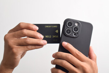 Male hands holding mobile phone and black credit card isolated on white background. Mobile payment ,Online shopping concept