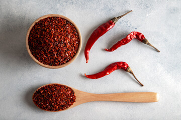 Red pepper flakes.Red chili peppers in wooden bowl on light blue background.Dried chili peppers
