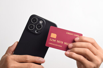 Male hands holding mobile phone and red credit card isolated on white background. Mobile payment ,Online shopping concept