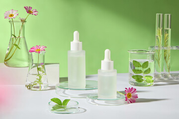 An advertising photo for skincare products, front view of a mockup of unlabeled dropper bottles placed on a glass podium, surrounded by some lab glassware containing natural plants. Green background.