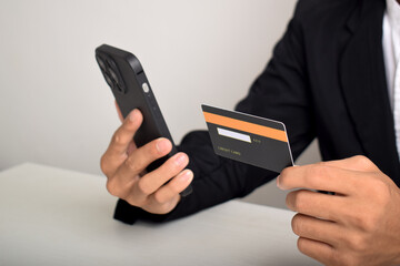 Man holding credit card and using smartphones at home.Online shopping, internet banking, store online, payment.