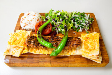 Grilled Turkish Adana, Urfa  Kebab with grilled vegetables, onion and rice on plate. Adana durum, Urfa durum .