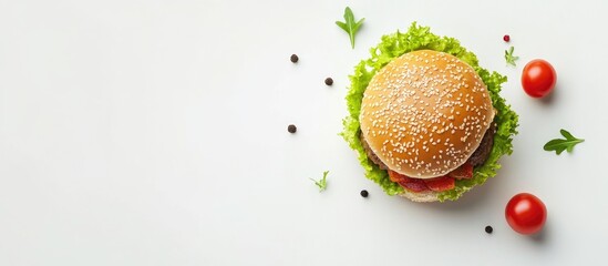 Delicious hamburger on a white background garnished with fresh vegetables and herbs providing ample space for promotional text