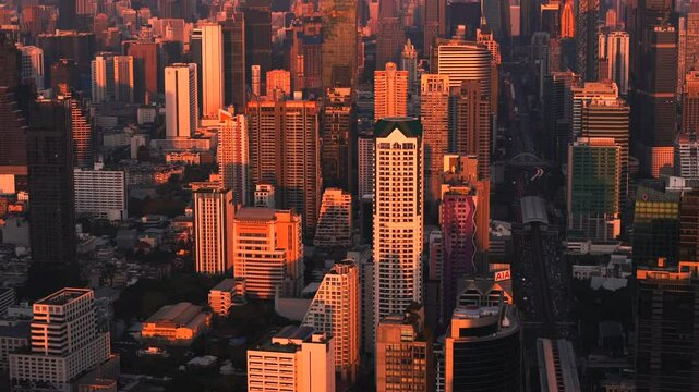 Bangkok high aerial view of Bang Rak and Si Lom districts at sunset. A large asian capital city with skyscrapers and millions of inhabitants. Cinematic 4k footage