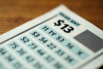 Lottery ticket closeup on a table, symbolizing hope and dreams of a better future, with a glimmer of anticipation and chance.