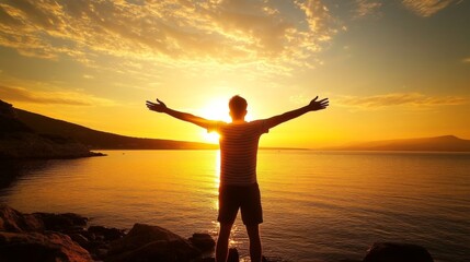 Fototapeta premium Young man enjoying sunset on rocky shore, arms Boy s silhouette