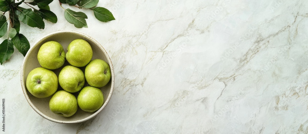 Poster fresh green apples in a bowl on marble countertop with empty space for text and leaves for elegant d