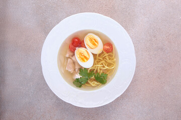 Chicken broth with egg. Dietary dish. Chicken noodle soup. Flat lay. Top view. Copy space.