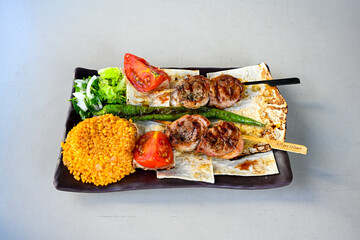 Famous Urfa meat liver, ciger wrapped by lavash with roasted chili pepper, onion and sauce in...