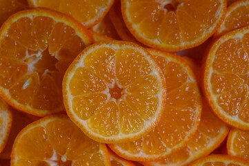 Vibrant orange slices arranged artistically on a surface during a bright afternoon