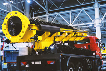 A drilling rig mounted on a truck, featuring a yellow boom and drilling mechanism. This equipment...