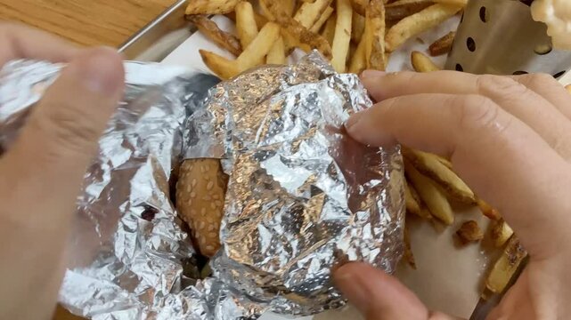 Eating a small hamburger with fries