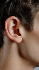  Close-up of a man's ear with fine details of skin and hair. Sharp focus emphasizes natural human anatomy and realistic texture, perfect for health or anatomy references.