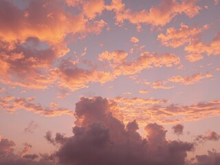 Fototapeta premium Fiery sunset paints the clouds vibrant orange and purple hues, fading to twilight blue, majestic, evening