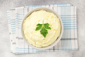 Mashed potatoes in white bowl on grey concrete background. Healt