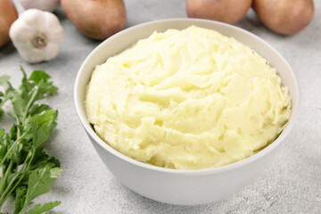 Mashed potatoes in white bowl on grey concrete background. Healt