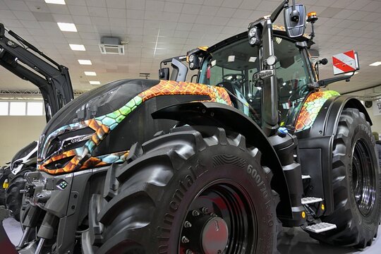 Left front view of front mask of modern powerful finish agricultural tractor Valtra Q, displayed on Agrosalon expo in Nitra, Slovakia, december 2024. Custom camouflage tuning foils applied.