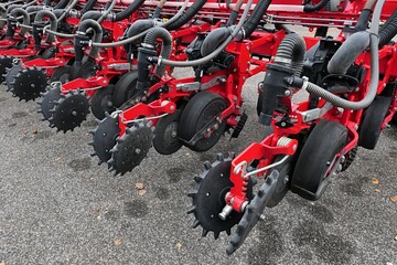 Rear detail of modern pneumatic agricultural seeder, furrow openers and seed press wheels visible...
