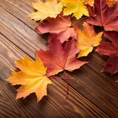 Obraz premium Autumn Maple Leaves on Rustic Brown Wooden Background, Generated image