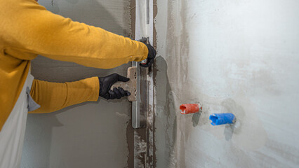 Applying a corner reinforcement tape into liquid membrane. Foolproof waterproofing for a tile bathroom.