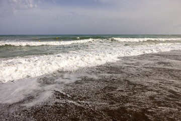  Foamy sea waves on the sandy beach of Bajondillo in Torremolinos, Malaga, Costa del Sol, Spain