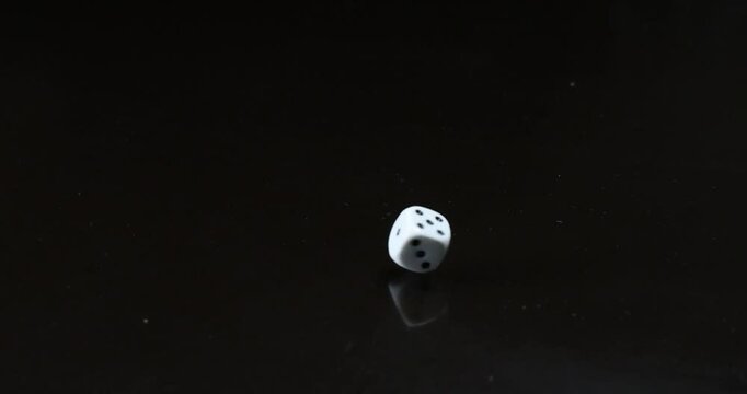 The dice are rolling across the table. Slow motion video