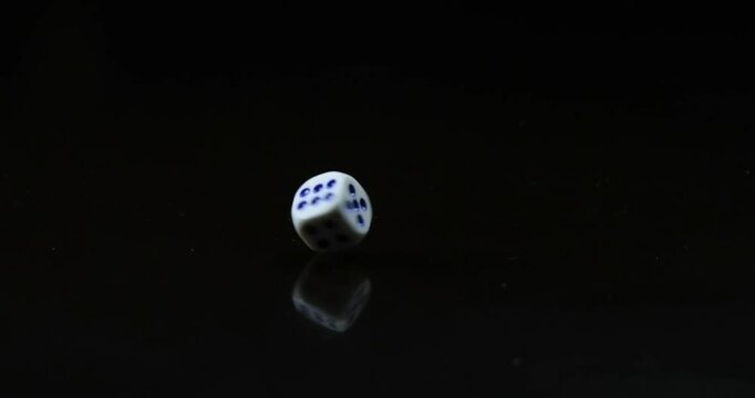 The dice are rolling across the table. Slow motion video