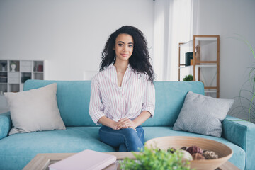 Portrait of nice young woman sit sofa chill wear striped shirt pastime modern interior flat indoors