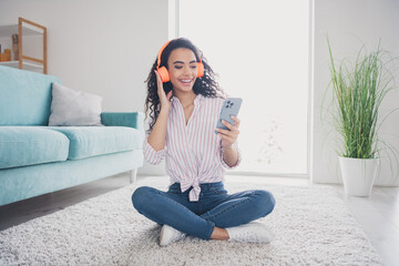 Full body portrait of nice young woman use phone touch headphones free time modern interior flat...