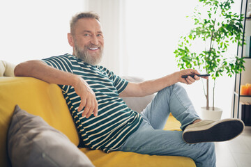 Happy senior man enjoying a relaxed day at home on a bright and cheerful weekend afternoon