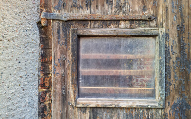 Old worn glass window on brown wooden wall. Space for your text and logo.