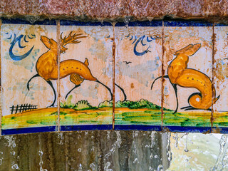Pattern of old style retro vintage hand painted wall decorative round shape ceramic tiles with blue lines on white closeup at a old spanish villa.