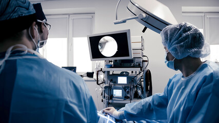 A group of medical surgeons in the operating room during an operation. A patient on the operating...