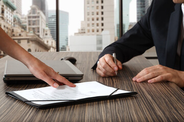 female hand pointing to businessman at signature place on a contract document