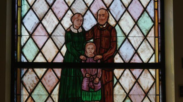 Stained glass of Saint Therese as a child in Catholic Church Natural lighting tilt shot
