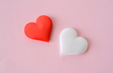 Obraz premium two red and white silk hearts isolated on the pink background macro